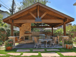 Bravos Landscape - Outdoor living Photo 1 Beautiful outdoor living design in a homeowners backyard consisting of a patio, kitchen, furntiture, and pavillion